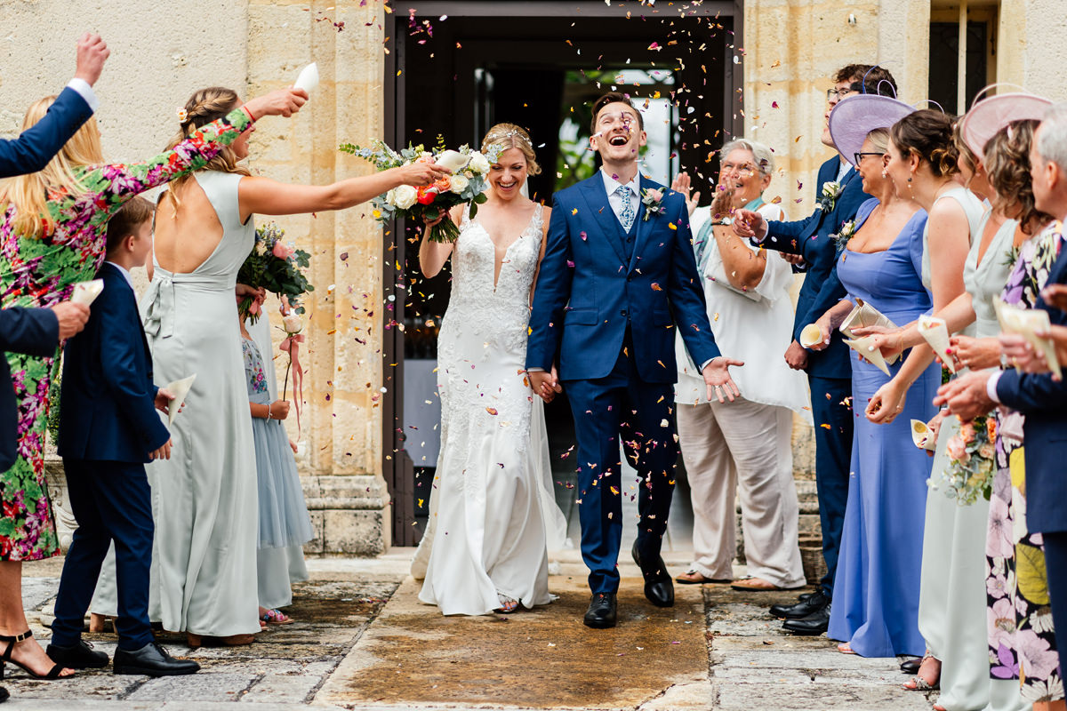 Bride and groom showered with confetti at Château de Soulac