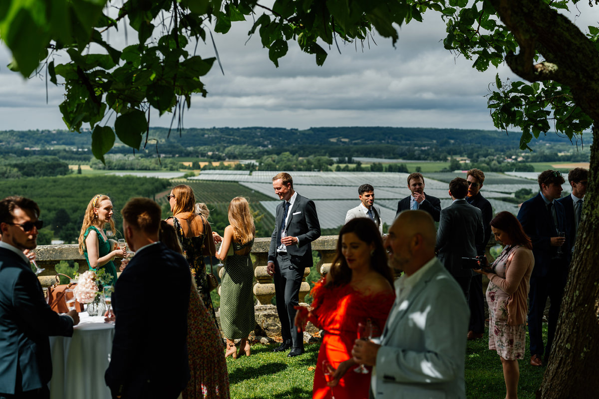 Wedding guests enjoy the drinks reception with views down to the Dordogne valley