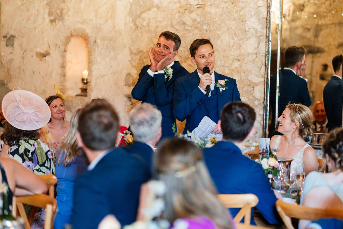 The groom giving his speech assisted by his best man.